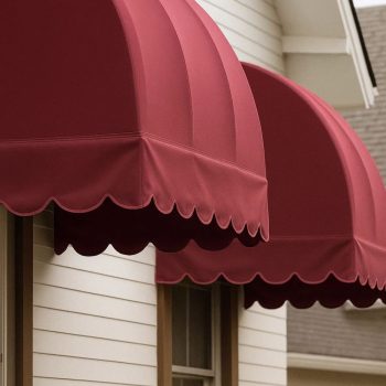 Toldo capota vermelho instalado em fachada com proteção lateral e frontal.