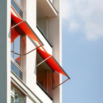 Toldo de braços retos Controsol instalado em varanda de edifício