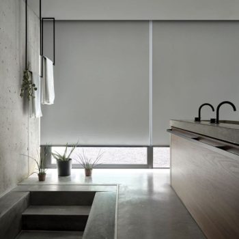 Estores de rolo instalados em janelas amplas, proporcionando controlo de luz, conforto térmico e design contemporâneo.