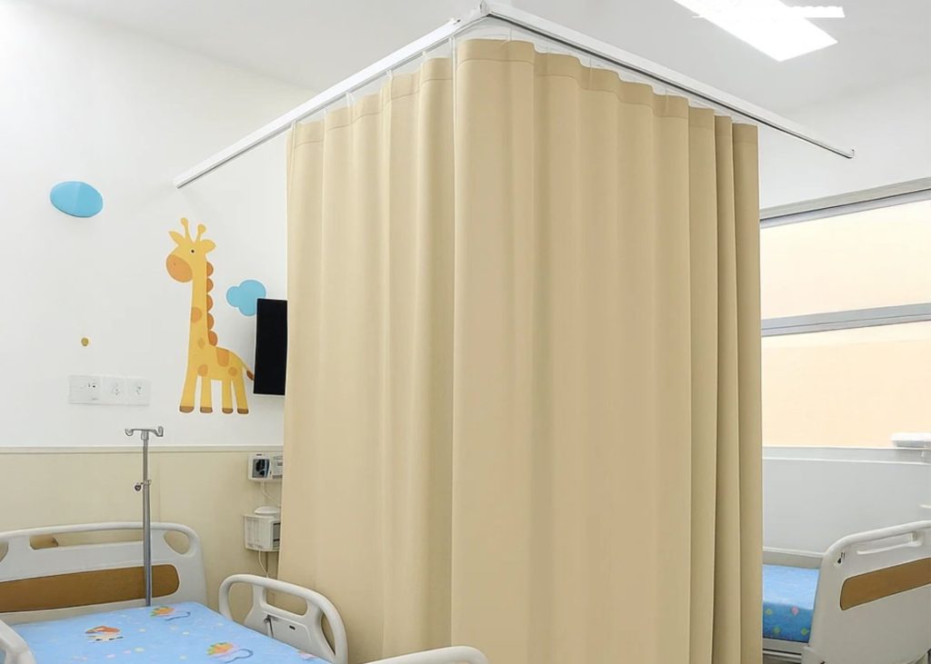 Cortina hospitalar instalada em quarto pediátrico com cama infantil ,exemplo visual de como escolher cortinas hospitalares adequadas ao ambiente clínico.