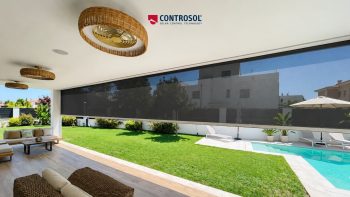Estores de rolo de grandes dimensões instalados num grande vão envidraçado com vista para o exterior