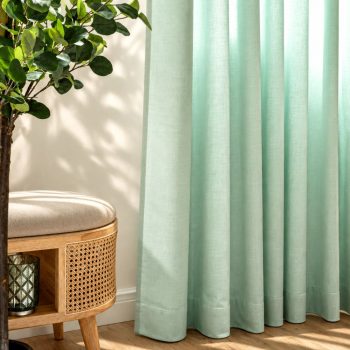 Cortinas em tecido acústico verde-claro instaladas numa sala